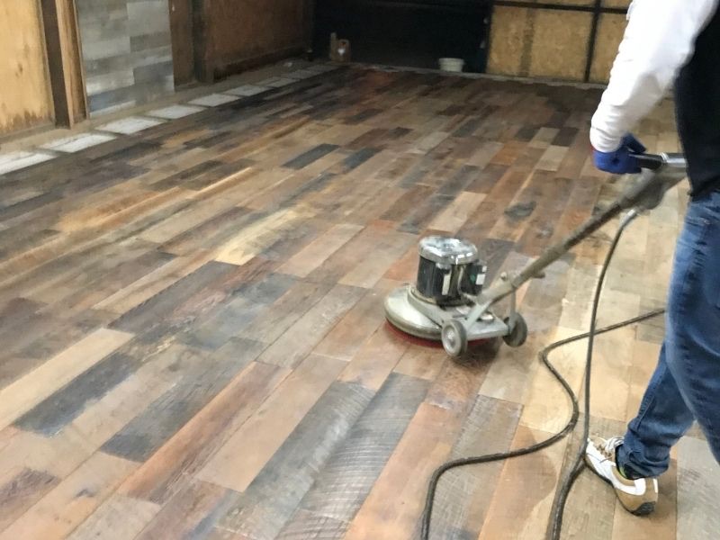 Hand-applied stain process on reclaimed parquet flooring